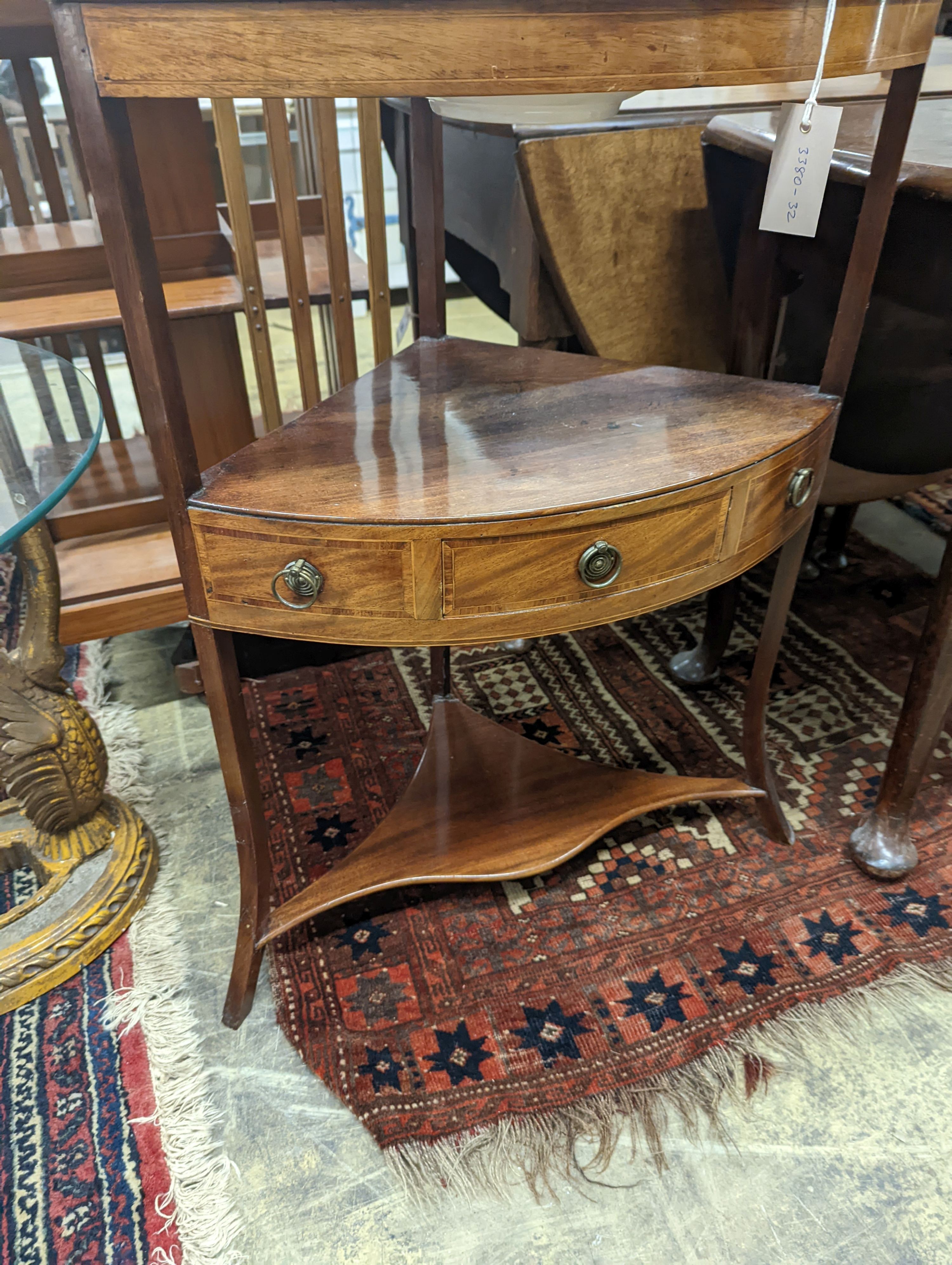 A George III mahogany bow front three tier corner washstand, width 58cm, depth 38cm, height 99cm with an associated jug and basin